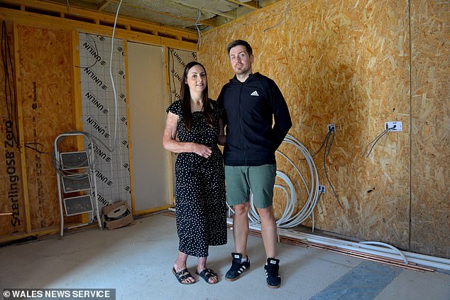 Jessica and Mike are pictured in their rebuilt home, happy to be back inside