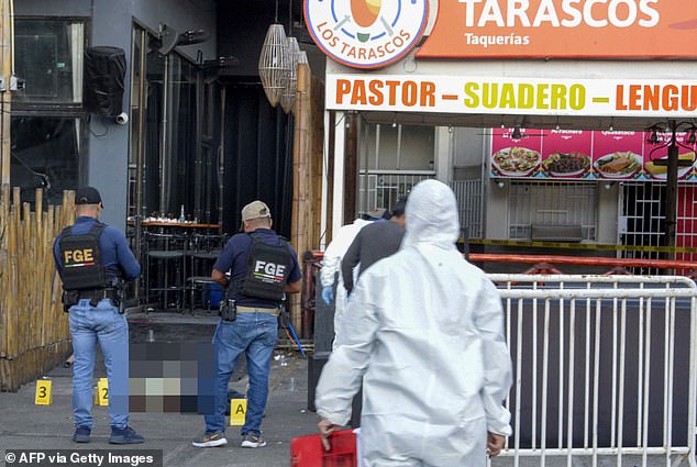 Police in Acapulco stand by the body of one of the five men who were shot and killed at Santana's Sports and Snacks Bar on December 5, 2022.  The seaside town, once a top destination for the Hollywood elite, is awash in crime, recording 65.6 homicides per 100 residents in 2022