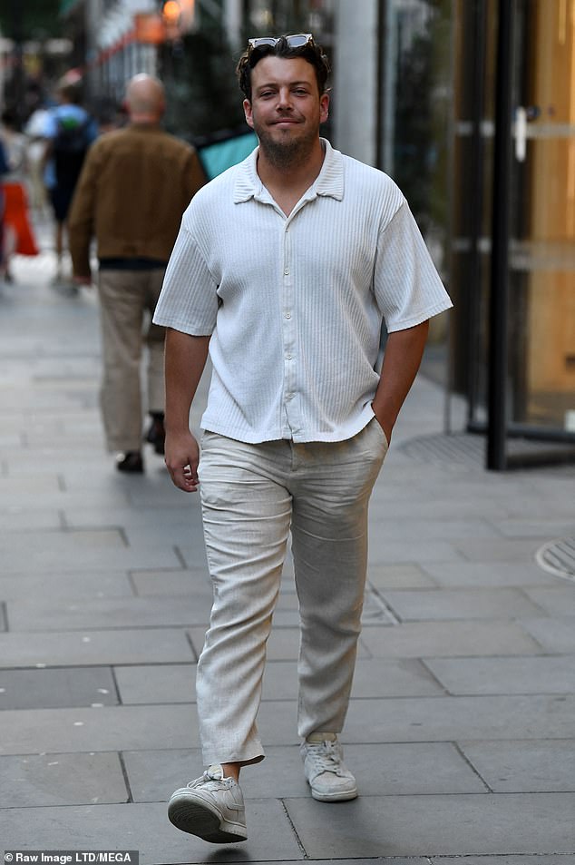 Cool: Diags looked smart in beige linen pants and a white short-sleeved shirt