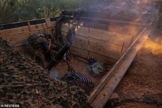 Ukrainian soldiers fire a mortar at Russian troops in their position near a front line