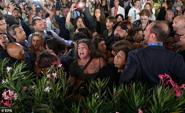 Protesters scream as Allen arrives for the premiere of Coup de Chance in Venice on Monday night