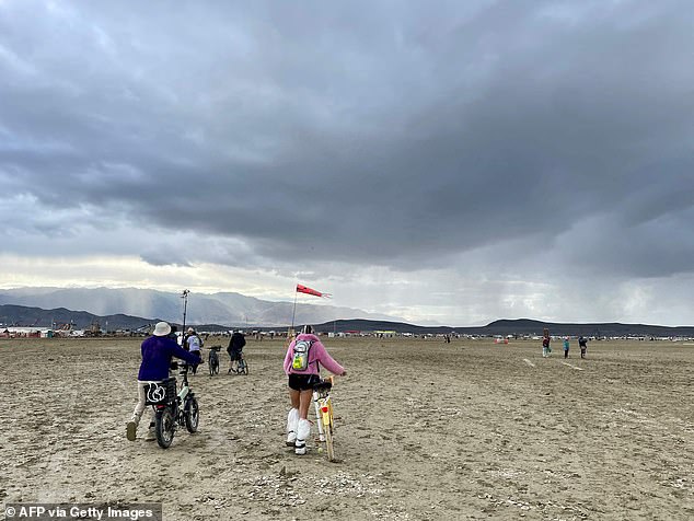 Participants walk through a muddy desert plain on Monday