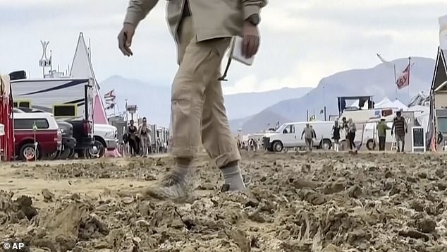 On Monday, a man makes his way through the mud in the desert