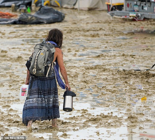 A Burning Man contestant makes his way through the mud in Black Rock City