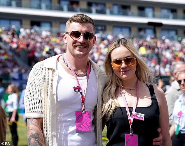 Adam Peaty, pictured with girlfriend Holly Ramsay at Silverstone in July, has reportedly been treated for a facial injury after being involved in a fight with a Team GB swimmate