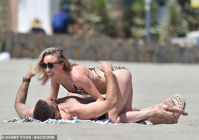 Smitten: The Hollyoaks star, 35, and her partner wrapped their arms around each other and shared several steamy kisses as they soaked up the sun