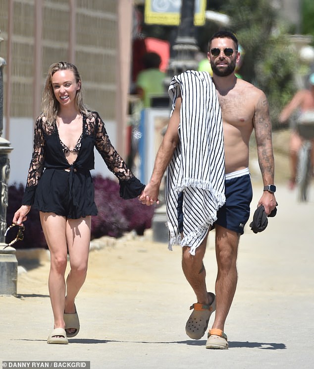 Sweet: Jorgie later wore a black lace playsuit while walking hand in hand with Oliver