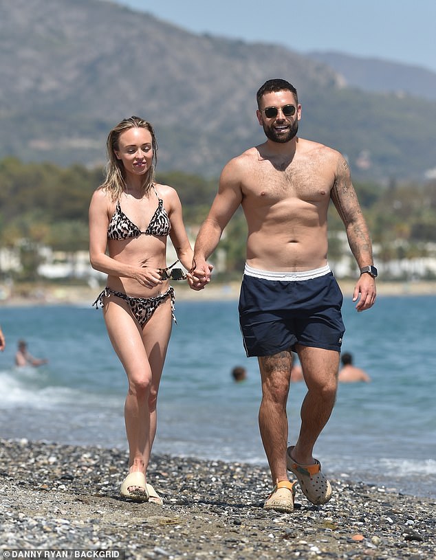 Looking good: Oliver showed off his muscular physique as he went topless while taking a dip in the sea