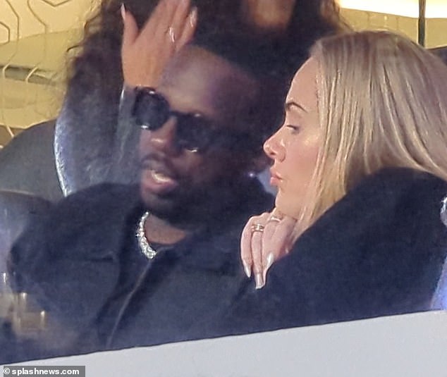 Close up: He shielded his eyes with dark square sunglasses and was seen talking to Adele as they listened to the music