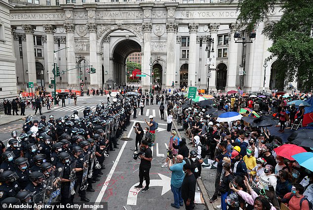 Police officers stand guard during Black Lives Matter protest as protesters block the streets at City Hall and Police Plaza, July 1, 2020