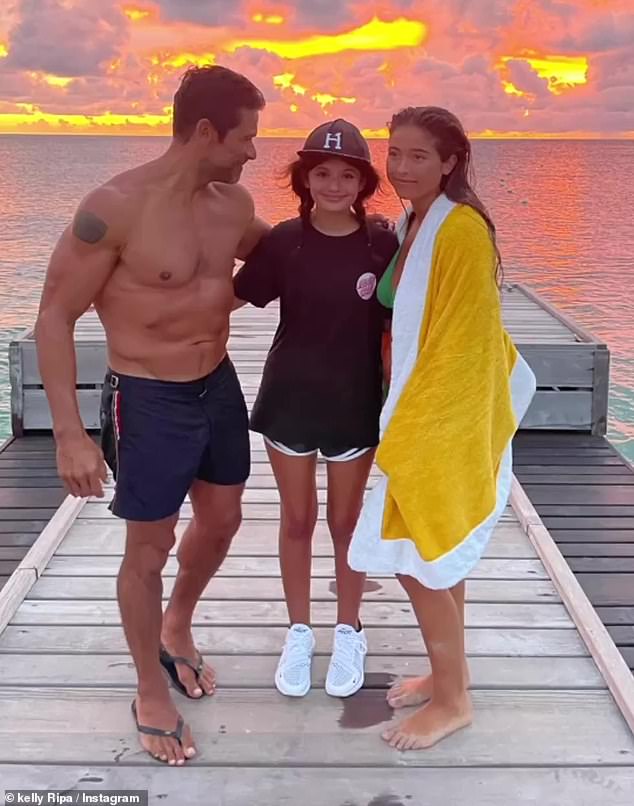 Beautiful sunset: Another photo showed Mark posing with their daughter Lola and their niece on the same pier in front of a beautiful sunset over the water