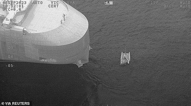 Cargo ship Dugong Ace (left) has rescued the sailors and is on its way to Brisbane