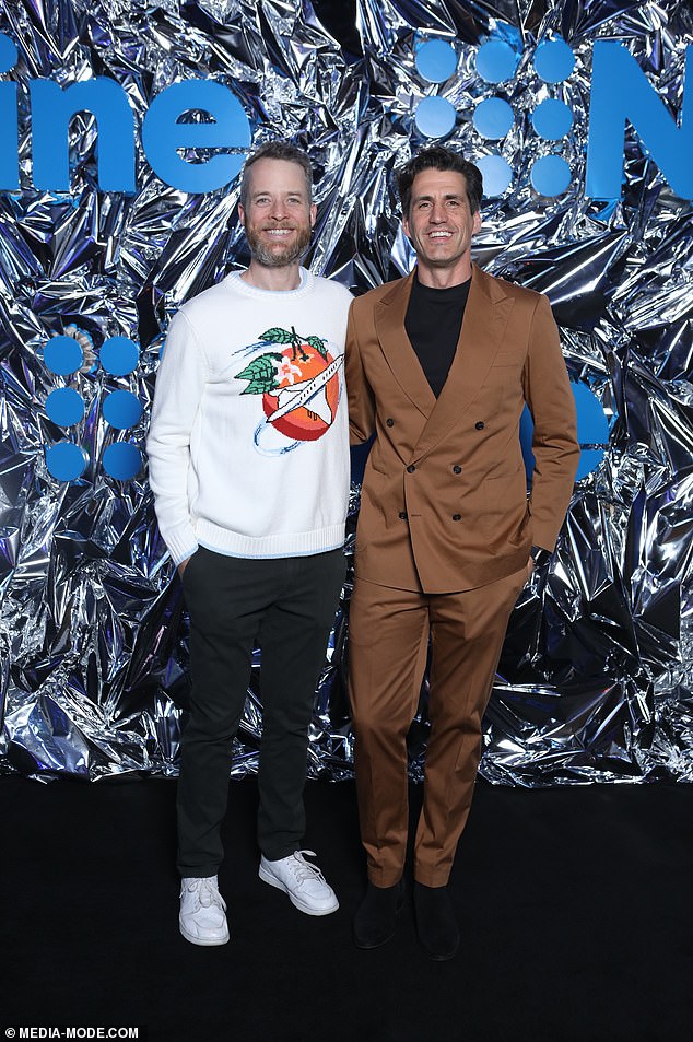 Lego Masters Australia host Hamish smiled in a white graphic jumper with a sky blue trim.  He paired the look with black pants and white sneakers