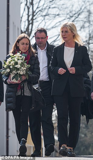 Ulrike Scharf (right), Minister of Family Affairs, leaves the Center for Child and Youth Care in April to lay flowers for the facility