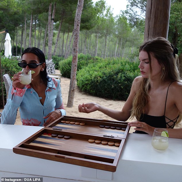 Antics: Dua enjoyed a cocktail with her friends as they played board games together during their summer vacation