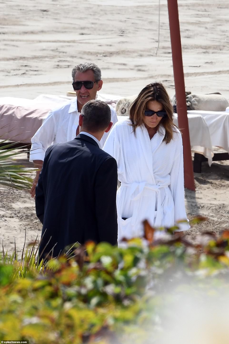 Bruni and Sarkozy left the beach in white robes and shirts