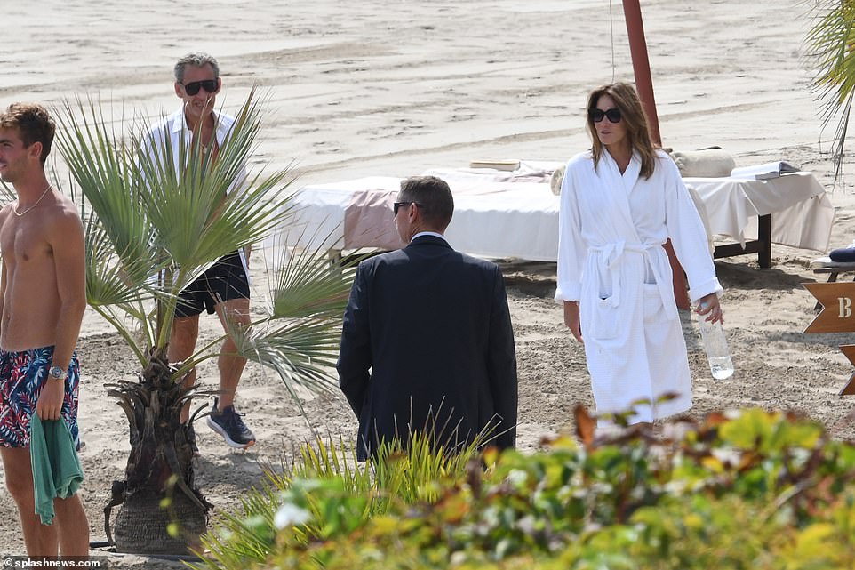 Bruni and Sarkozy left the beach in white robes and shirts