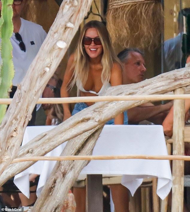 Good form: Lottie seemed in a jovial mood as she smiled and laughed at a beachside restaurant