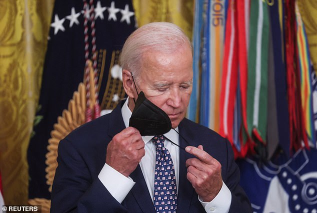 President Biden removes his face mask during the ceremony