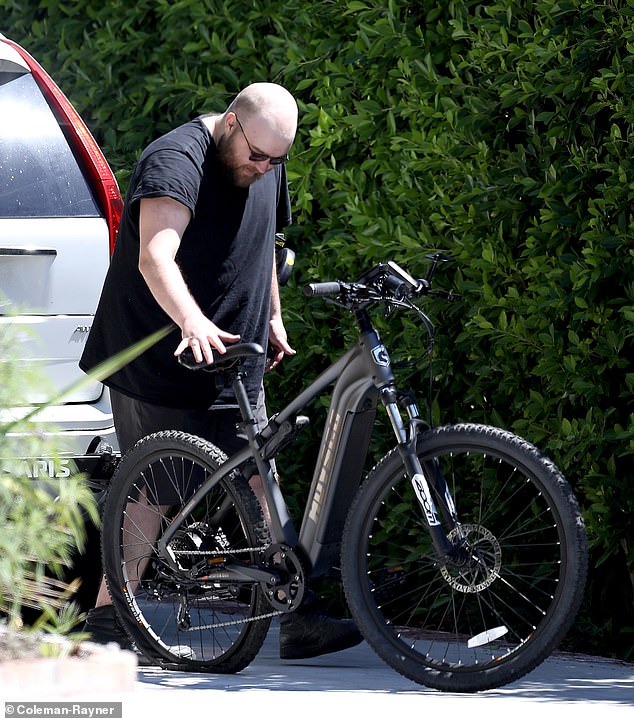 He was also seen pushing an electric bicycle that appeared to have a flat tire