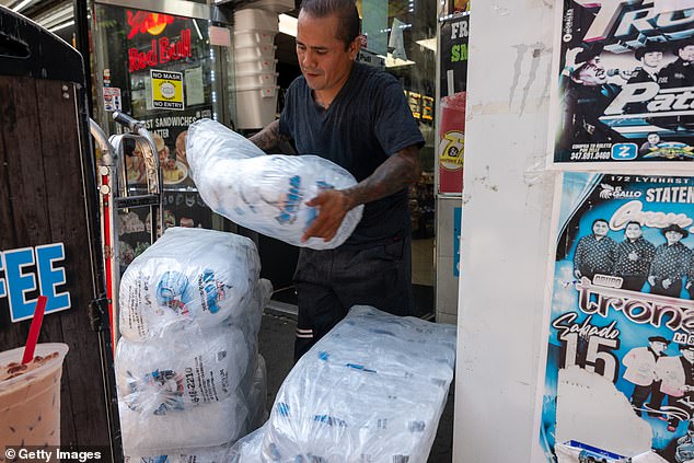 Also on Coney Island, a worker delivers bags and bags of ice to a grocery store during the heat wave