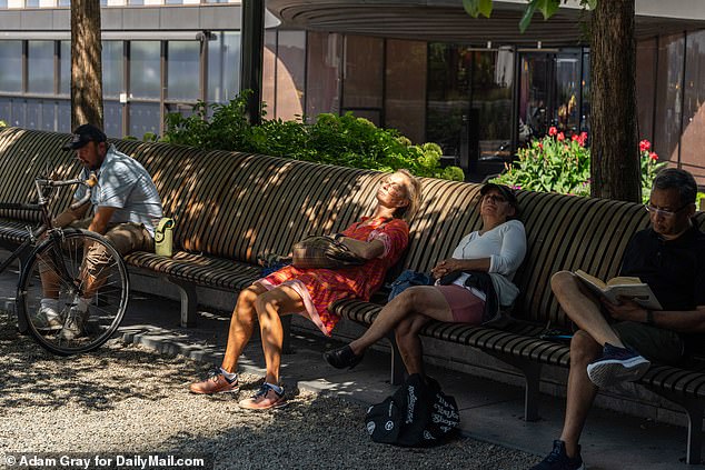 Some New Yorkers sit on benches at a screening of the US Open in the Hudson Yards, played in the intense heat in Queens