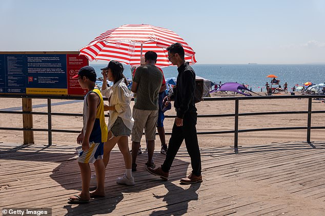 People cool off by the water at Coney Island on September 6, 2023 in the Brooklyn borough of New York City