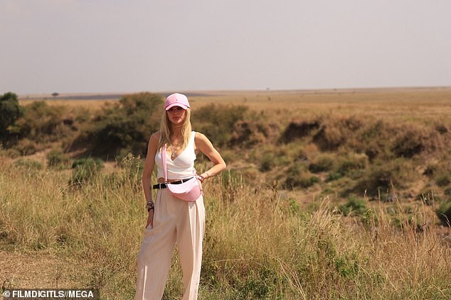 Pretty in pink: With one outfit change, she traded in her fedora hat for a pink ball cap and a matching bag