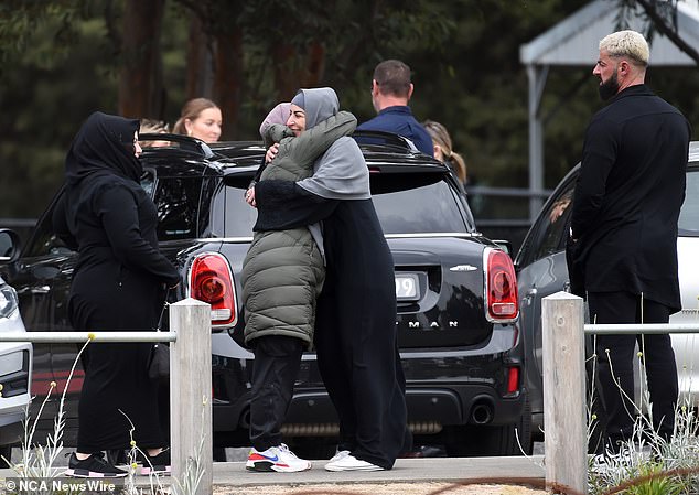 Two women hugged in a parking lot before entering the Australian Islamic Center on Thursday