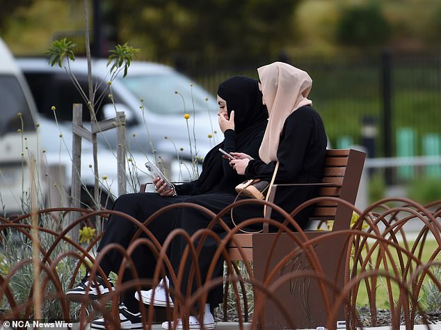 Two women sat on a bench nearby before the memorial service for Ali, 17, and Zena, 18, began