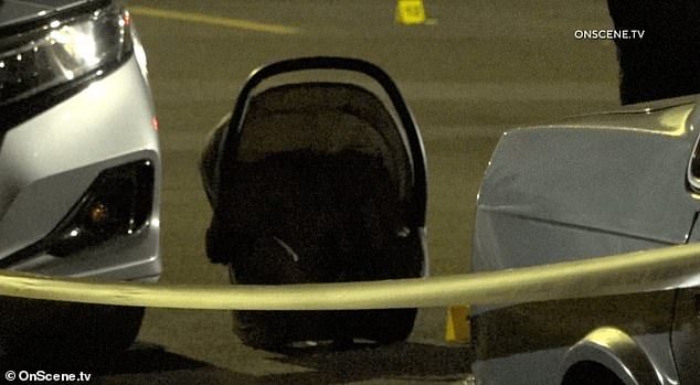 Video of the scene shows the driver's seat of several police cars marked with bullet holes, while the child's car seat remains on the road in a taped area