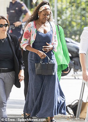 She looked stylish in a low-cut denim dress and a designer handbag