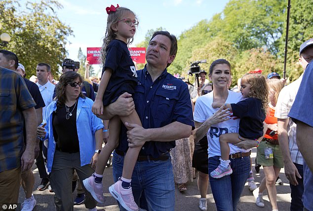 Republican presidential nominee for Florida Governor Ron DeSantis holds his daughter Madison as he walks alongside his wife Casey DeSantis