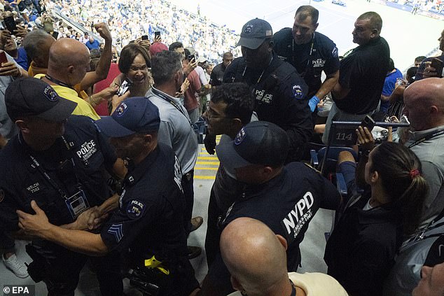 New York City police officers escort a protester away after interrupting the semifinal