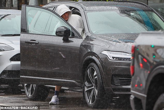 He paired the baggy look with long blue socks and spotless white trainers