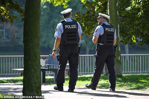 German police officers patrol the waterfront near the hotel on Friday