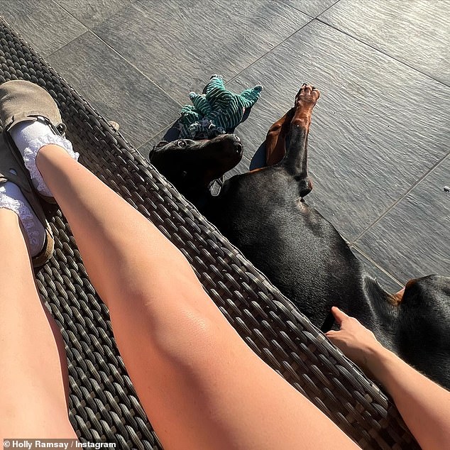 Legs eleven: Later enjoying the sun, she again used her dog as a crutch as she lay on a sunbed in a pair of Birkenstocks