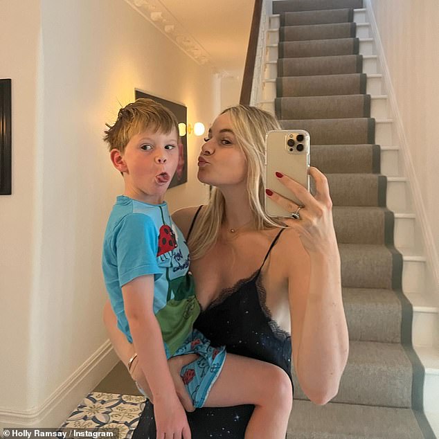 Kiss kiss: Holly looked stunning in the snaps, which included a photo of her picking up her brother - youngest Ramsay child Oscar, four