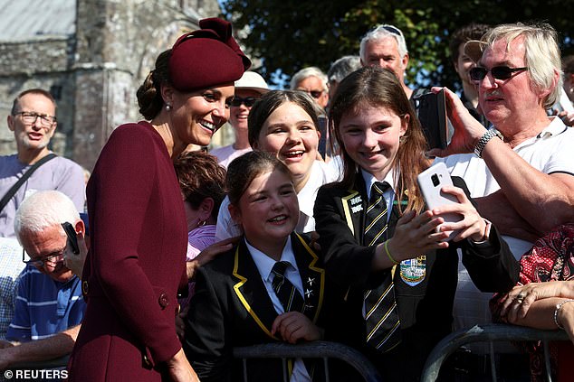 The Princess of Wales takes a selfie with well-wishers and schoolchildren today as she visits St David's Cathedral