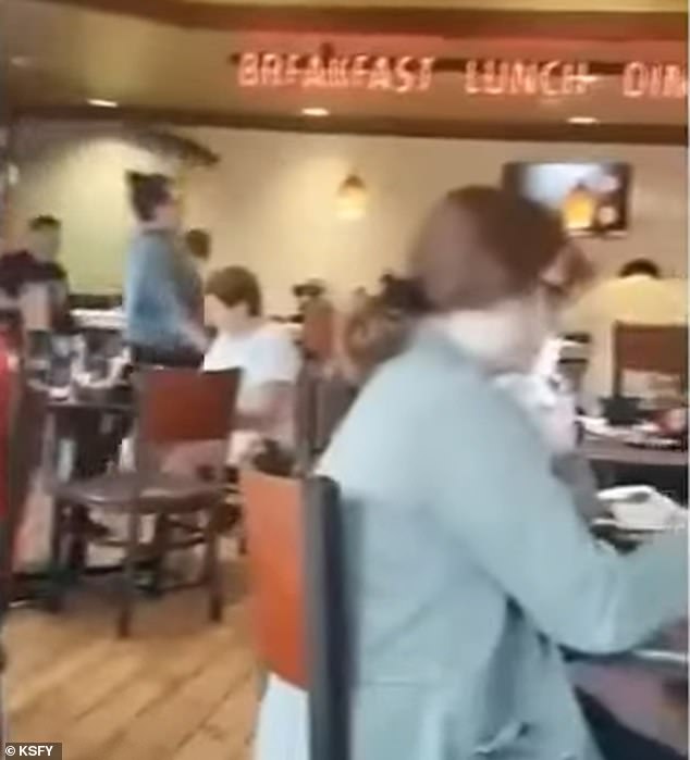 The waitress she ignored is seen in green with a tray over her head