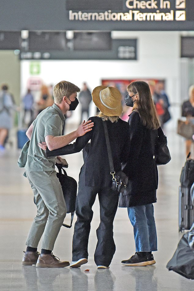 He walked through the terminal in khaki straight-leg jeans and a polo shirt, while wearing a matching khaki jacket.