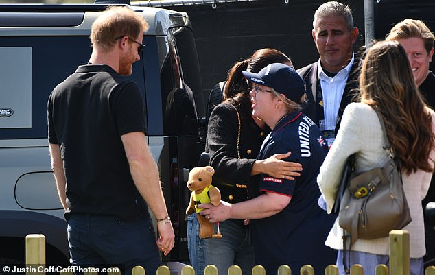 Mr Sanchez watches as Harry and Meghan are greeted by a fan with a hug