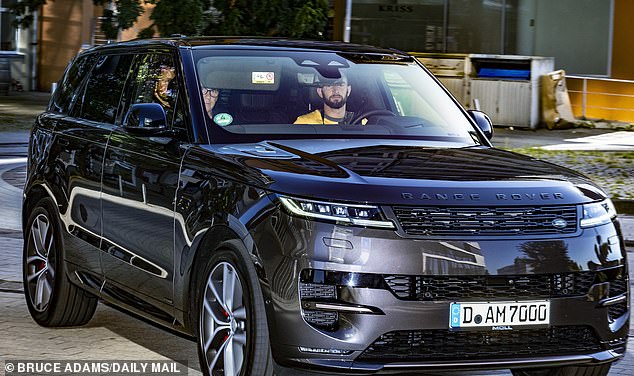 Prince Harry – in the back passenger seat of the Range Rover – arrives at his hotel in Düsseldorf on Friday