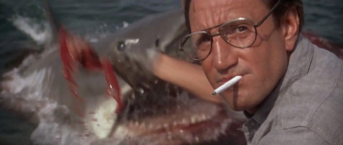 Roy Scheider as Martin Brody who scoops his buddy into the ocean, unaware of the great white shark that appears in the water in Jaws.