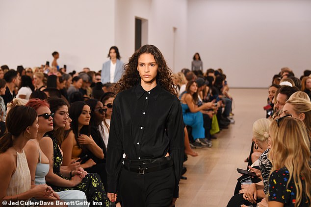 A look: A model wore a black button-up shirt tucked into black slacks