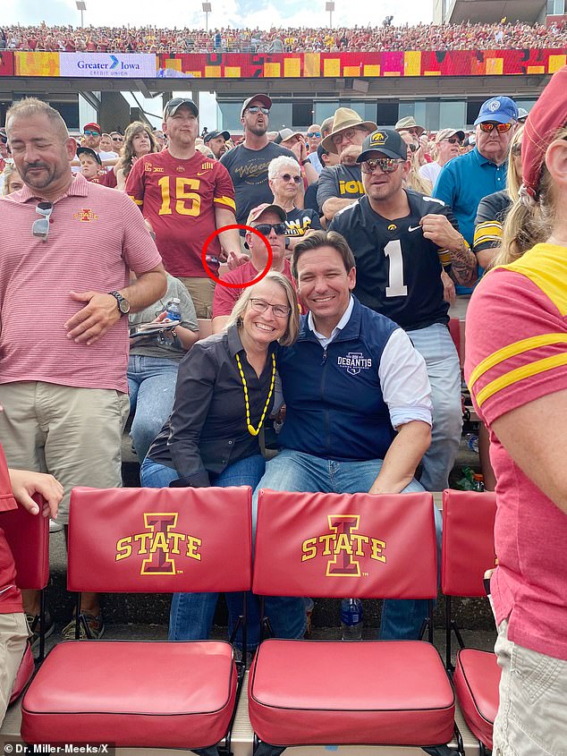 DeSantis was seen shaking hands and taking selfies with voters during the game, with one cheeky fan taking the opportunity to flip him the bird in the background of a photo