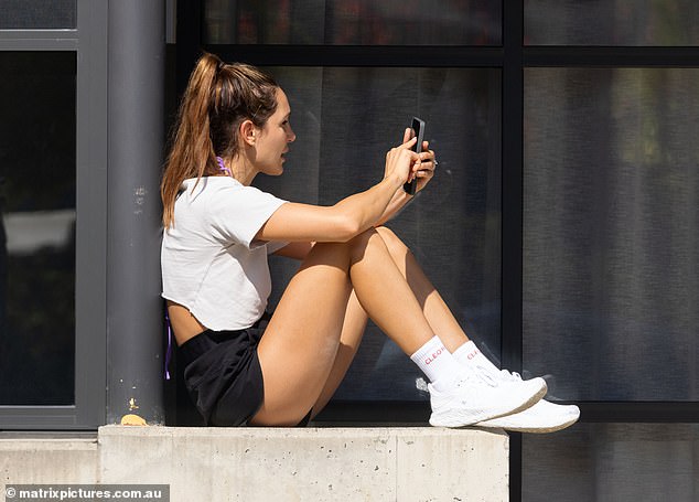 At one point, she sat on a concrete edge and played on her cellphone