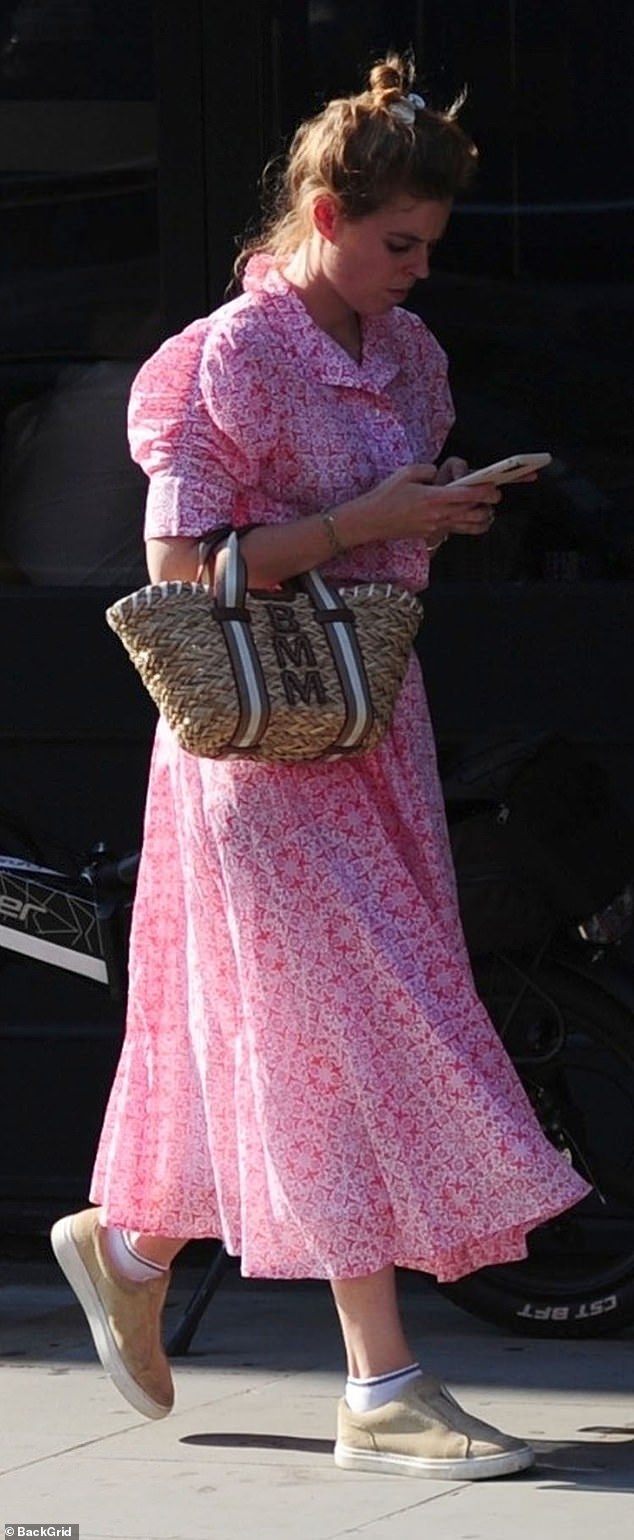 She wore a midi pink dress with a floating collar and a pattern, which she paired with a pair of comfortable beige loafers.