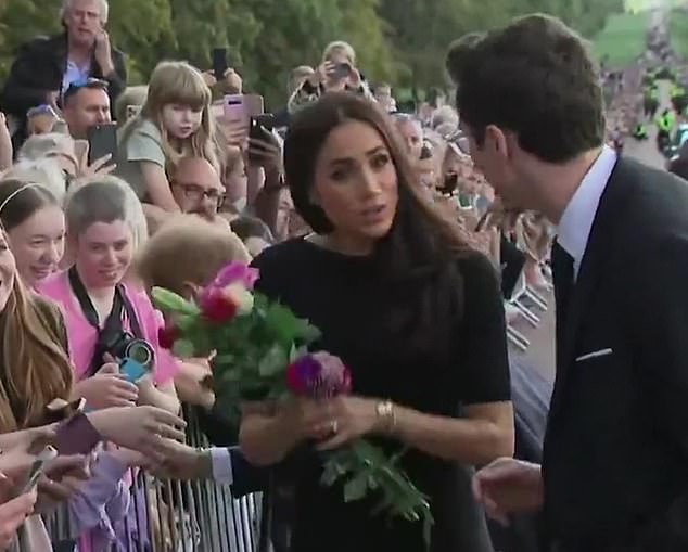 When Meghan was approached by an assistant who wanted to take the growing number of floral tributes from her, footage showed her telling him she wanted to continue holding them.