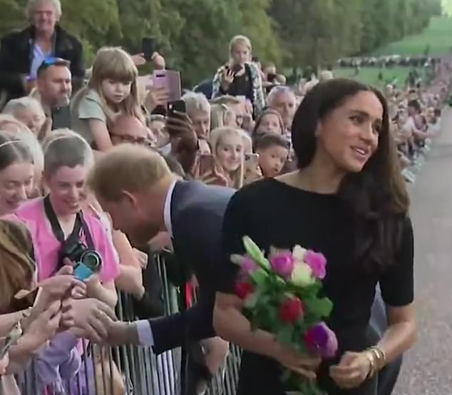 The assistant turns around and Meghan still has the flowers firmly in her hand